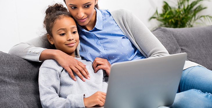 Mother and Daughter on Laptop on Couch