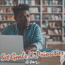 Calm Afro-American looking into the distance while sitting with laptop with text overlay that says, "Set goals and priorities."